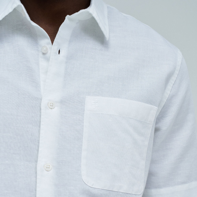 Camisa de manga curta em linho, perfeita para os dias quentes. Cor branco puro com fit regular que se adapta confortavelmente ao corpo. Apresenta decote clássico com colarinho, abertura frontal com botões funcionais e bolso prático no peito. O linho garante respirabilidade e um toque natural, ideal para criar looks casual e sofisticados. Uma peça versátil que combina com calças, shorts ou saias para qualquer ocasião.
