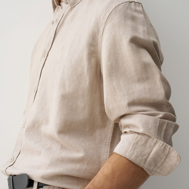Camisa de linho em tom bege que combina conforto e elegância. Corte regular que se adapta perfeitamente ao corpo, com decote de colarinho clássico e mangas compridas. Abertura frontal com botões para um visual versátil e fácil de usar. Ideal para criar looks sofisticados tanto no dia a dia como em ocasiões mais formais. A mistura de linho garante respirabilidade e um toque natural que envelhece com estilo.