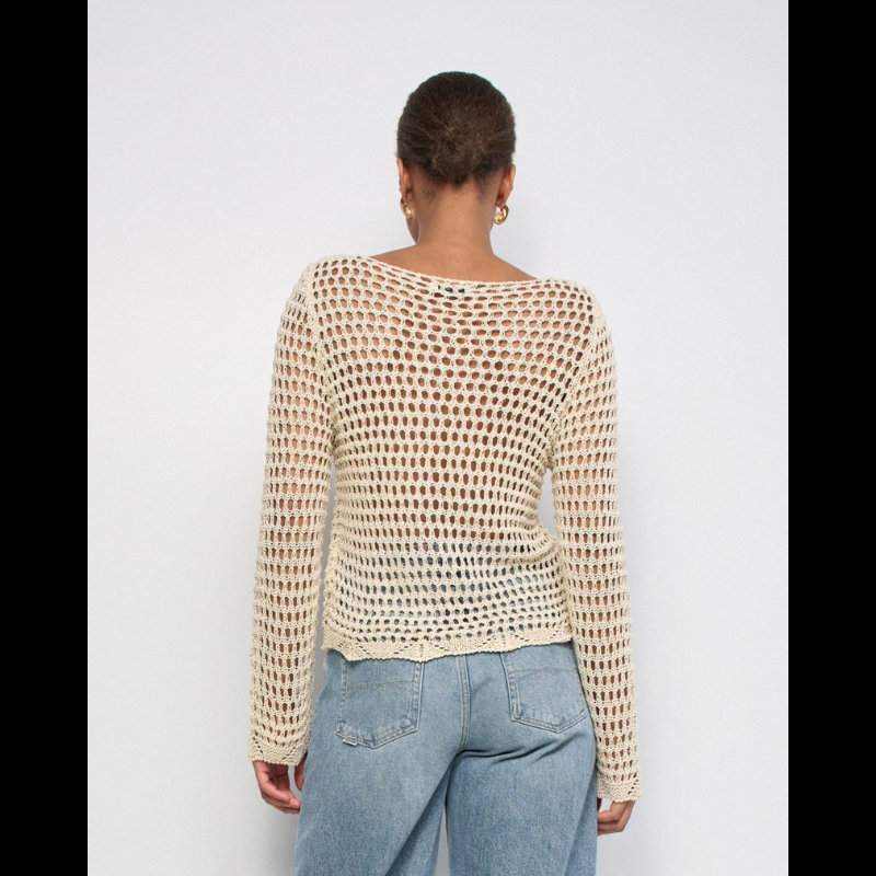 Camisola de malha elegante em bege com fios de Lurex que capturam a luz de forma subtil. Apresenta decote em barco que alarga visualmente os ombros, manga comprida e um padrão de rede com transparência estratégica que adiciona sofisticação ao visual. O fit regular oferece conforto sem apertar, ideal para looks casuais ou mais refinados. Inclui forro na parte da frente que permite usar a peça sem preocupações, garantindo discrição e funcionalidade.
