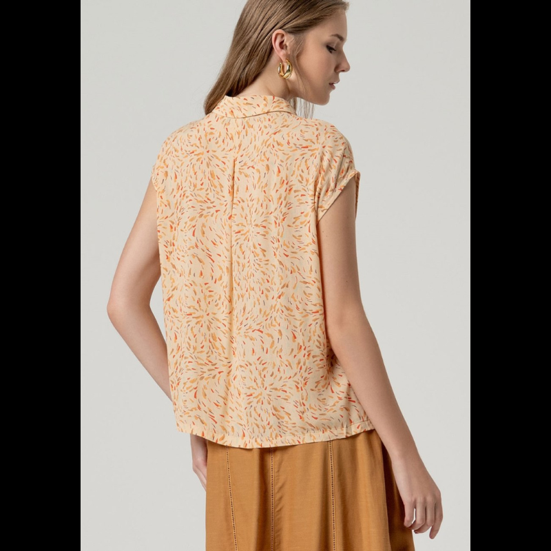 Camisa sem mangas SURKANA em tom areia com padrão vibrante em laranja, vermelho e castanho. Fechamento frontal com botões para um ajuste personalizado. Corte solto e leve, perfeito para dias quentes, com prega-macho na parte de trás que proporciona conforto e movimento. Uma peça versátil para criar looks descontraídos e elegantes.