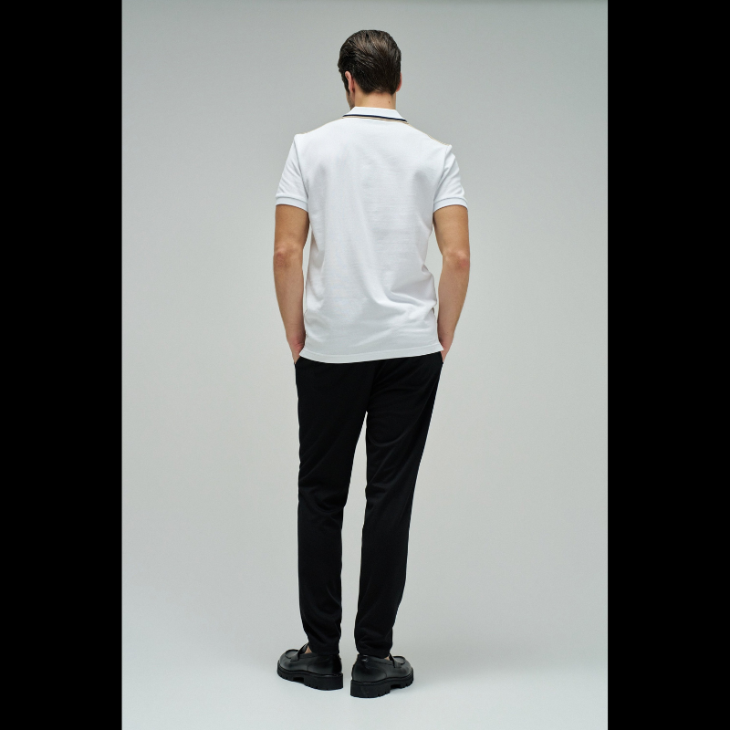 Polo clássico em branco com fit regular e mangas curtas. Apresenta decote de colarinho com botões e detalhe de riscas no colarinho que adiciona um toque de sofisticação. Perfeito para um visual casual e versátil, combina conforto com estilo contemporâneo. Ideal para o dia a dia ou ocasiões mais descontraídas.