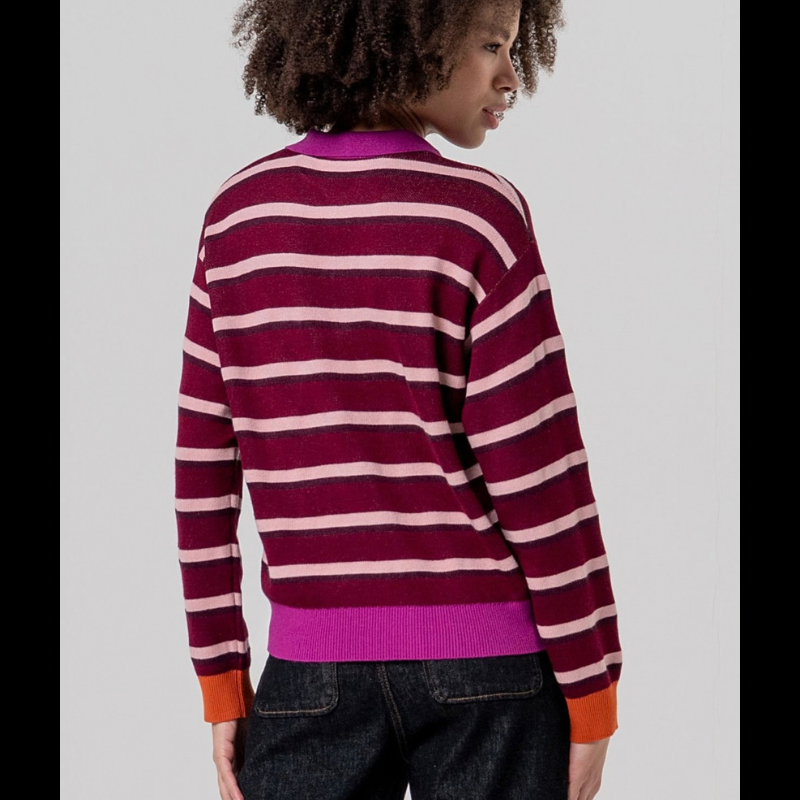 Camisola de malha de manga comprida com gola em polo com três botões. Camisola listrada com grená, rosa claro e bordô. Punhos a terminar em laranja e cós e gola em rosa forte.
