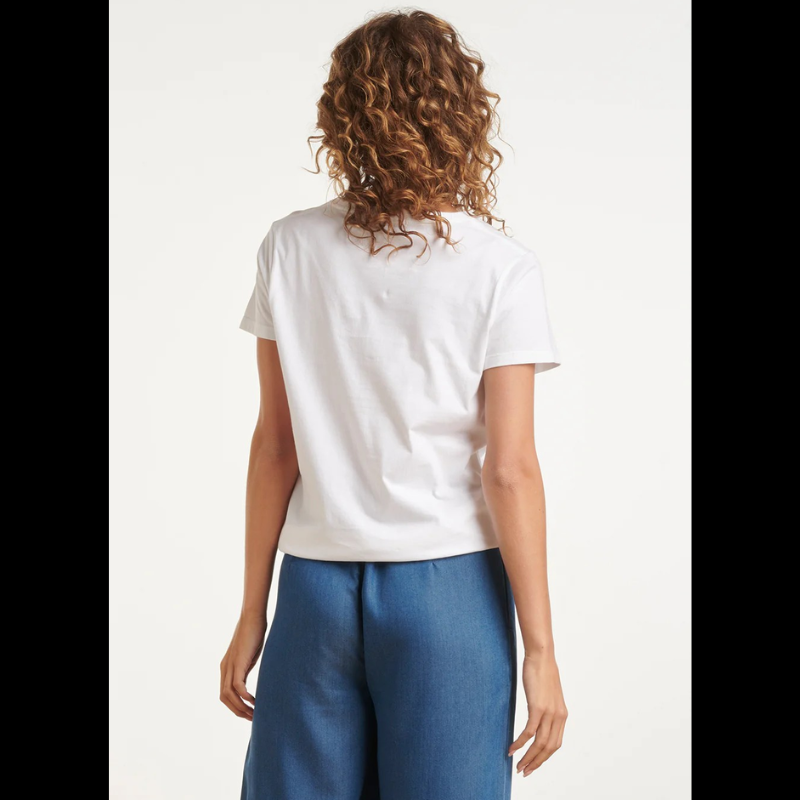 T-shirt de manga curta branca com estampa "Ciel Parisien" em azul e vermelho. Design gráfico inspirado na elegância parisiense, perfeito para um look casual e descontraído. Tecido confortável e de qualidade, ideal para o dia a dia. Combine com calças ou saias para criar diferentes estilos.