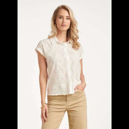 Blusa branca de manga curta, adornada com um padrão floral delicado em detalhes de bordado refinado. Fechamento frontal com botões.