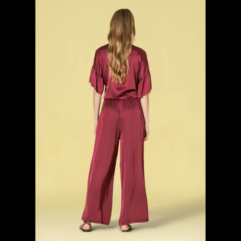Blusa em tecido acetinado, em bordeaux, com acabamento sofisticado e confortável. Modelo oversize que oferece liberdade de movimento e um visual descontraído e elegante. Decote redondo clássico que combina com qualquer estilo. Mangas curtas com detalhe em folho, adicionando um toque feminino e delicado ao design. Fechamento frontal com botões funcionais, permitindo ajuste perfeito ao corpo. Peça versátil ideal para looks do dia a dia ou ocasiões mais descontraídas.