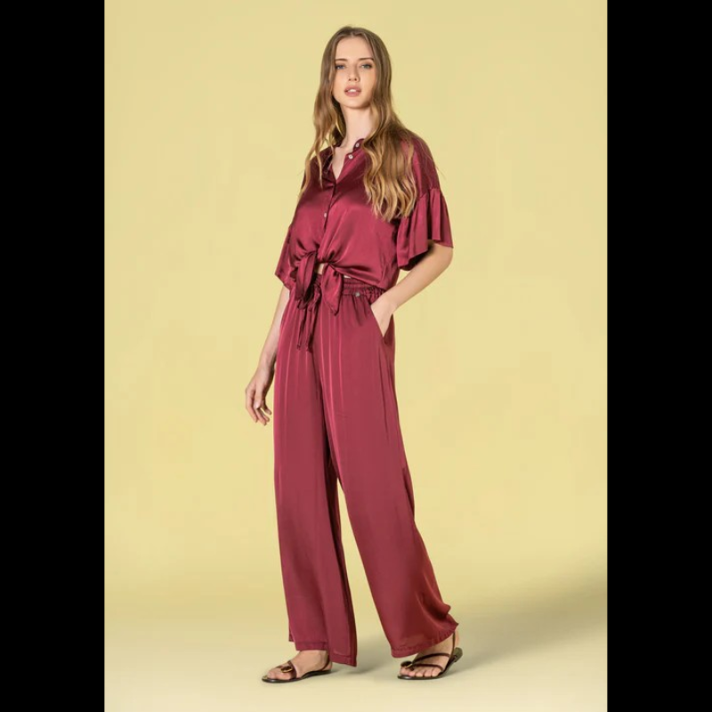 Blusa em tecido acetinado, em bordeaux, com acabamento sofisticado e confortável. Modelo oversize que oferece liberdade de movimento e um visual descontraído e elegante. Decote redondo clássico que combina com qualquer estilo. Mangas curtas com detalhe em folho, adicionando um toque feminino e delicado ao design. Fechamento frontal com botões funcionais, permitindo ajuste perfeito ao corpo. Peça versátil ideal para looks do dia a dia ou ocasiões mais descontraídas.