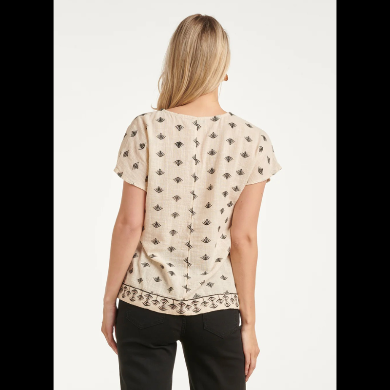 Blusa bege em algodão com manga curta e decote em V elegante. Destaca-se pelo bordado gráfico asteca em preto e castanho, que adiciona carácter e sofisticação ao design. Peça versátil, perfeita para criar looks casuais ou semi-formais. Confortável e fácil de combinar com calças ou saias.