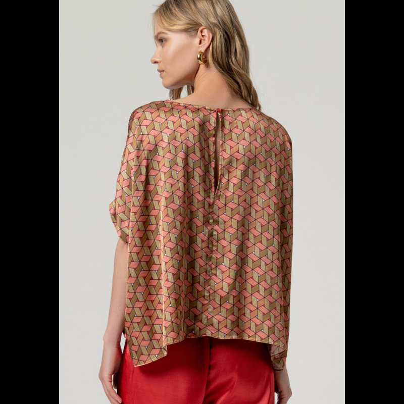 Esta blusa capa SURKANA apresenta um design refinado em acetinado com motivos geométricos vibrantes que combinam vermelho e múltiplas tonalidades. O decote circular e silhueta oversize oferecem liberdade de movimento e elegância atemporal, enquanto o fecho traseiro com botão garante um ajuste seguro e discreto. Uma escolha sofisticada para quem valoriza qualidade e estilo.