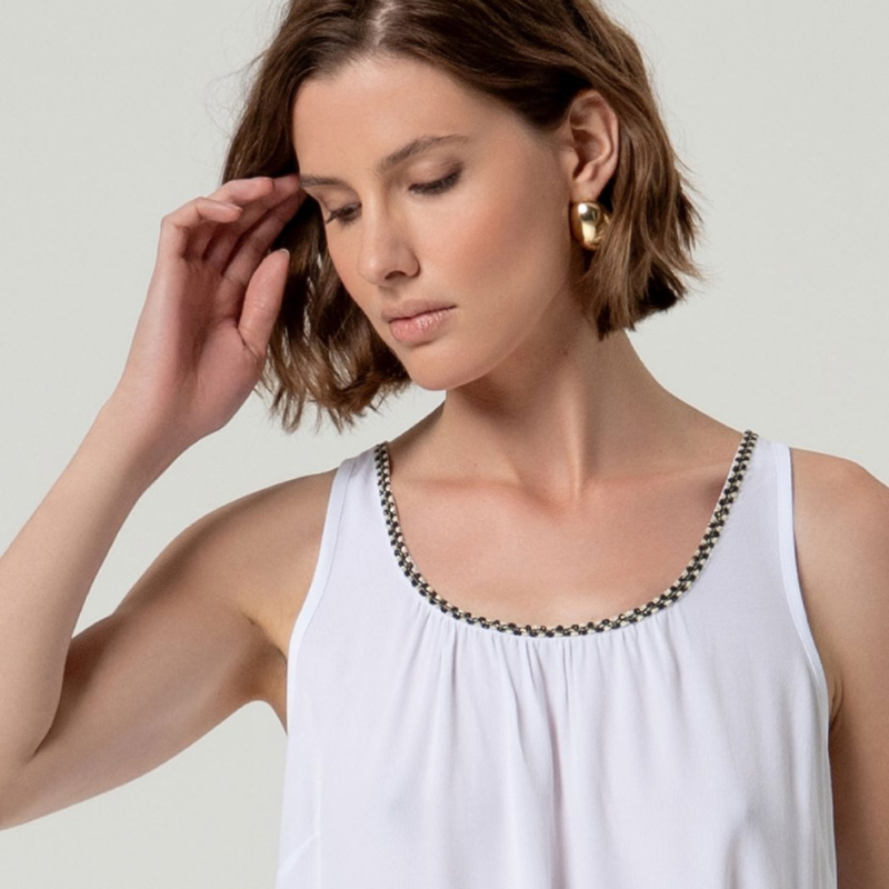 Top de alças em viscose ecovero, perfeito para dias quentes e descontraídos. Decote arredondado com detalhe elegante em preto e dourado que adiciona sofisticação ao visual. Corte solto e suave que oferece conforto máximo, com costas lisas e sem fechamento. Peça versátil que combina com facilidade em looks casuais ou mais refinados.