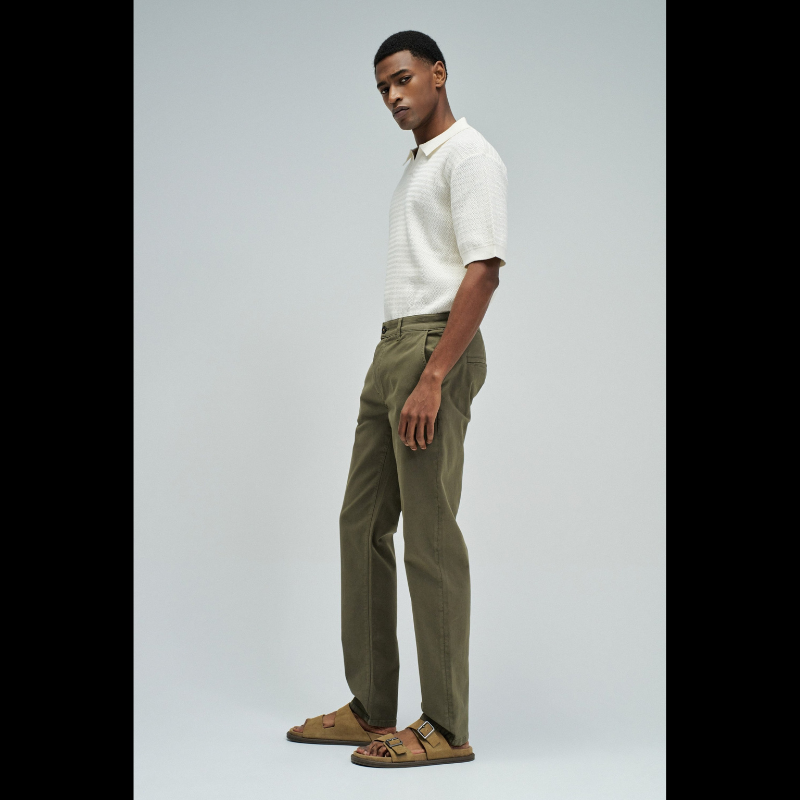 Calça chino em verde com cintura média e corte slim que combina estilo e conforto. Apresenta quatro bolsos funcionais, presilhas para cinto e abertura prática com fecho de correr e botão. Peça versátil ideal para o dia a dia, oferecendo um visual moderno e bem ajustado.