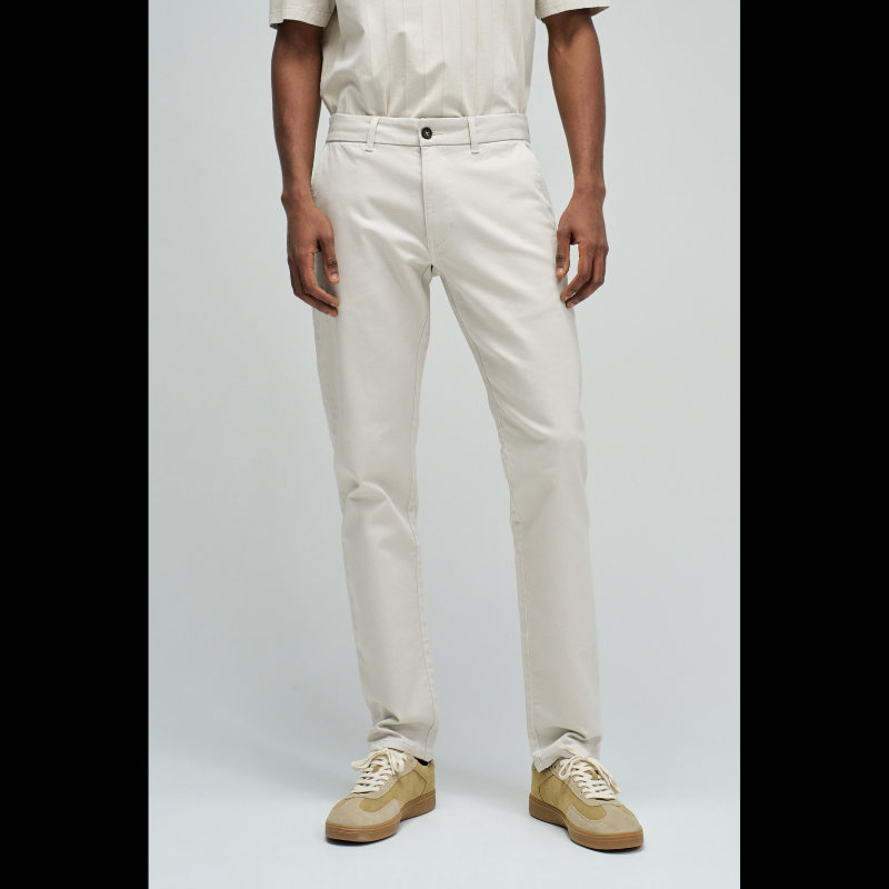 Calças chino de corte slim fit que combinam estilo e conforto. Confecionadas em tom cru neutro, apresentam cintura média com cordão interno ajustável para um encaixe personalizado. O design inclui quatro bolsos funcionais e presilhas, garantindo versatilidade no dia a dia. Ideais para criar looks casual refinados ou composições mais formais, estas calças adaptam-se facilmente a diferentes ocasiões e estilos pessoais.