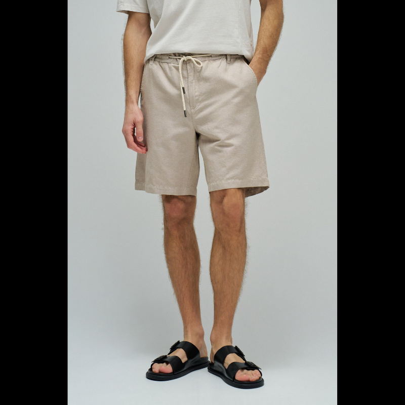 Calções em linho com um toque de sofisticação casual. O corte regular e a cintura média proporcionam conforto e elegância, enquanto o fecho de correr e botão garantem segurança. O cordão ajustável permite um ajuste personalizado conforme necessário. Quatro bolsos funcionais e presilhas completam o design prático. A cor bege neutra combina facilmente com qualquer peça do seu guarda-roupa, tornando estes calções uma escolha versátil para dias quentes.