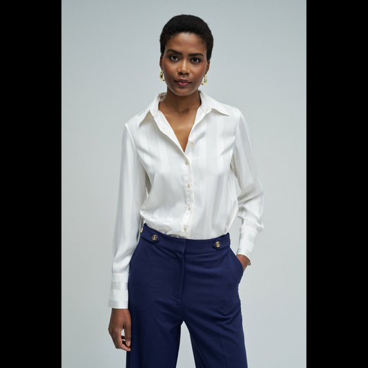 Camisa acetinada de corte regular com riscas em Lurex que adiciona um toque de sofisticação ao seu guarda-roupa. Confecionada em branco puro, apresenta mangas compridas e decote de colarinho clássico. O fecho frontal com botões e os punhos abotoados garantem um ajuste preciso e confortável. Ideal para ocasiões que exigem elegância discreta com um detalhe luminoso.