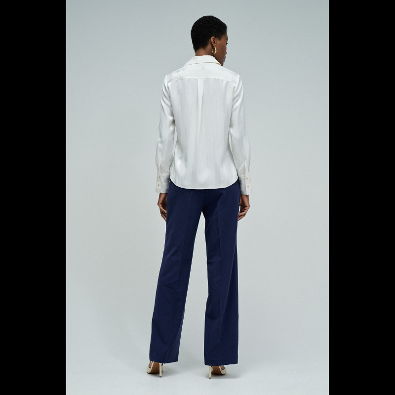 Camisa acetinada de corte regular com riscas em Lurex que adiciona um toque de sofisticação ao seu guarda-roupa. Confecionada em branco puro, apresenta mangas compridas e decote de colarinho clássico. O fecho frontal com botões e os punhos abotoados garantem um ajuste preciso e confortável. Ideal para ocasiões que exigem elegância discreta com um detalhe luminoso.