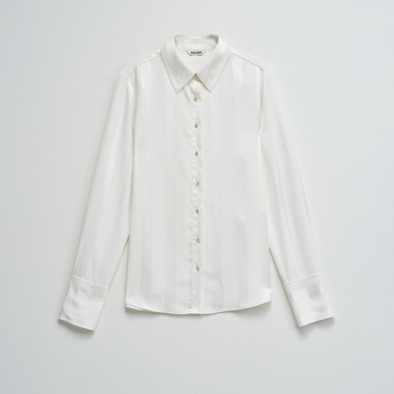 Camisa acetinada de corte regular com riscas em Lurex que adiciona um toque de sofisticação ao seu guarda-roupa. Confecionada em branco puro, apresenta mangas compridas e decote de colarinho clássico. O fecho frontal com botões e os punhos abotoados garantem um ajuste preciso e confortável. Ideal para ocasiões que exigem elegância discreta com um detalhe luminoso.