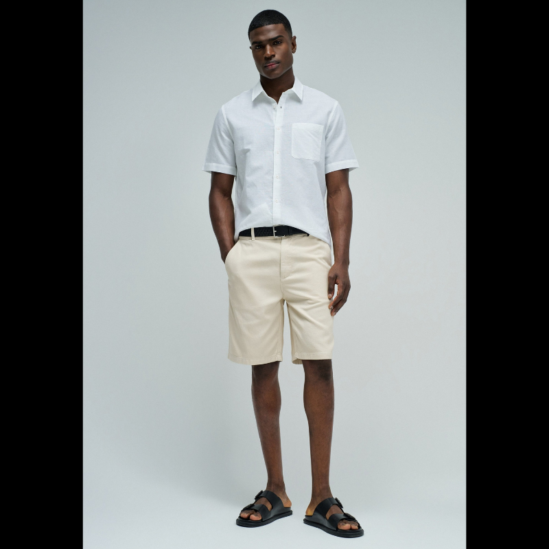 Camisa de manga curta em linho, perfeita para os dias quentes. Cor branco puro com fit regular que se adapta confortavelmente ao corpo. Apresenta decote clássico com colarinho, abertura frontal com botões funcionais e bolso prático no peito. O linho garante respirabilidade e um toque natural, ideal para criar looks casual e sofisticados. Uma peça versátil que combina com calças, shorts ou saias para qualquer ocasião.