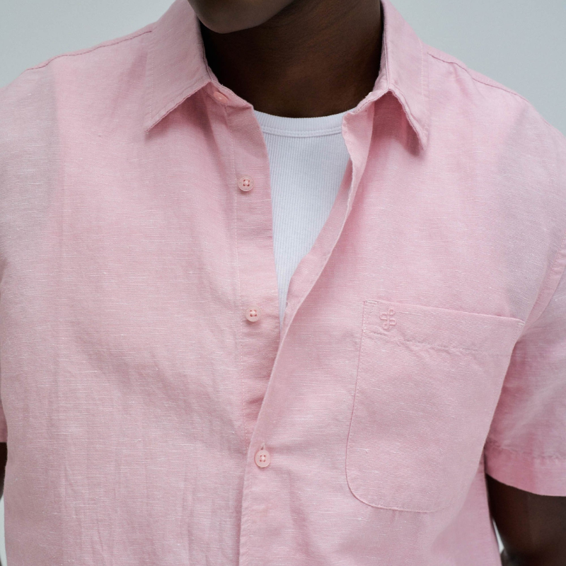 Camisa de manga curta em linho, perfeita para os dias quentes. Cor rosa com fit regular que se adapta confortavelmente ao corpo. Apresenta decote clássico com colarinho, abertura frontal com botões funcionais e bolso prático no peito. O linho garante respirabilidade e um toque natural, ideal para criar looks casual e sofisticados. Uma peça versátil que combina com calças, shorts ou saias para qualquer ocasião.