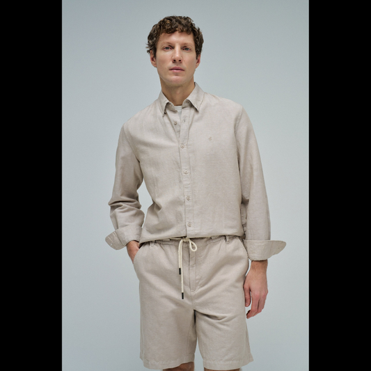 Camisa de linho em tom bege que combina conforto e elegância. Corte regular que se adapta perfeitamente ao corpo, com decote de colarinho clássico e mangas compridas. Abertura frontal com botões para um visual versátil e fácil de usar. Ideal para criar looks sofisticados tanto no dia a dia como em ocasiões mais formais. A mistura de linho garante respirabilidade e um toque natural que envelhece com estilo.