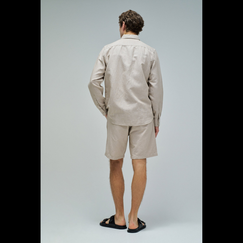 Camisa de linho em tom bege que combina conforto e elegância. Corte regular que se adapta perfeitamente ao corpo, com decote de colarinho clássico e mangas compridas. Abertura frontal com botões para um visual versátil e fácil de usar. Ideal para criar looks sofisticados tanto no dia a dia como em ocasiões mais formais. A mistura de linho garante respirabilidade e um toque natural que envelhece com estilo.