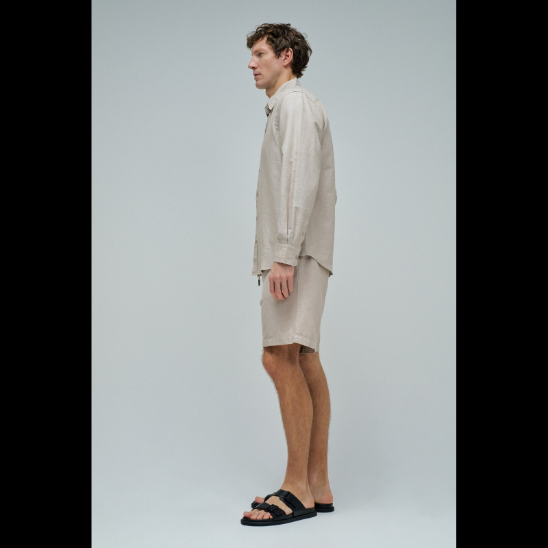 Camisa de linho em tom bege que combina conforto e elegância. Corte regular que se adapta perfeitamente ao corpo, com decote de colarinho clássico e mangas compridas. Abertura frontal com botões para um visual versátil e fácil de usar. Ideal para criar looks sofisticados tanto no dia a dia como em ocasiões mais formais. A mistura de linho garante respirabilidade e um toque natural que envelhece com estilo.