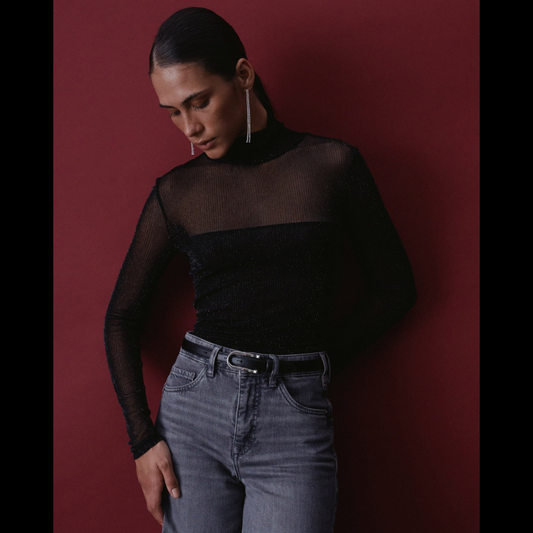 Camisola de tule em preto com um toque sofisticado e elegante. Corte slim que acompanha perfeitamente o seu corpo, com decote gola alta para um visual contemporâneo e refinado. Mangas compridas adornadas com fios lurex que capturam a luz e conferem brilho subtil ao conjunto. A transparência estratégica na zona dos ombros e mangas cria um efeito visual interessante, combinando sensualidade com sofisticação.