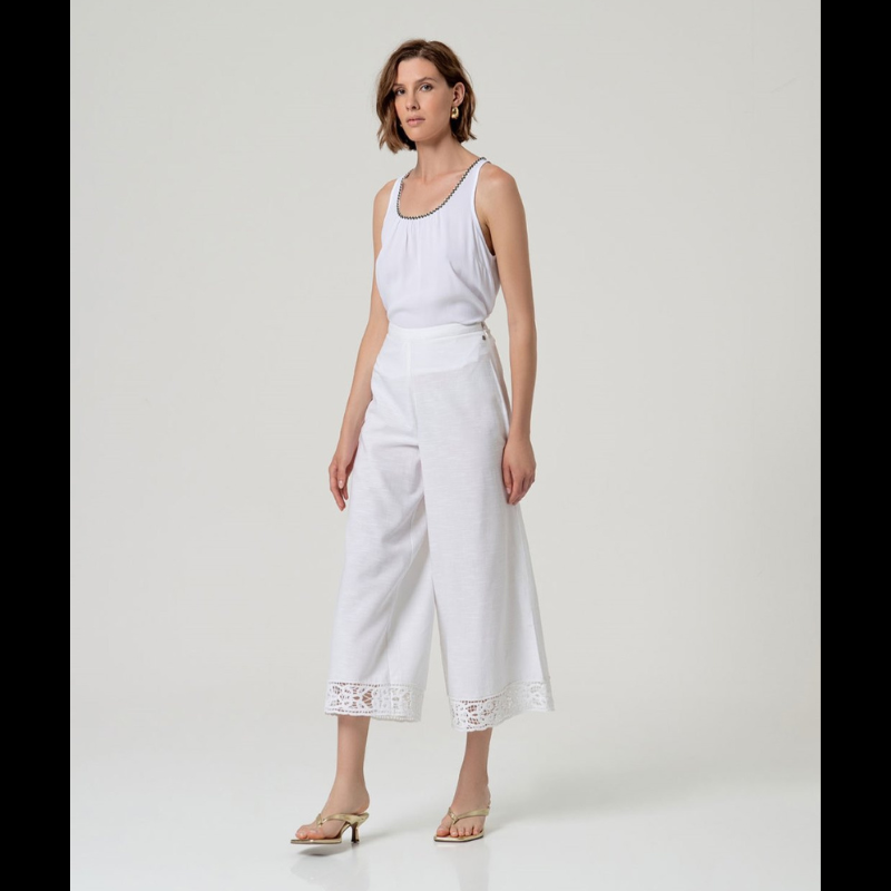 Calça flare em branco que combina elegância e conforto. Cintura alta com fecho de lado e colcheta, complementada por elástico na parte traseira para um ajuste perfeito. A barra apresenta um delicado detalhe de bordados abertos que confere um toque sofisticado ao design. Confecionada em viscose e algodão, oferece leveza e respirabilidade ideais para o dia a dia. Uma peça versátil que se adapta a diversos estilos e ocasiões.