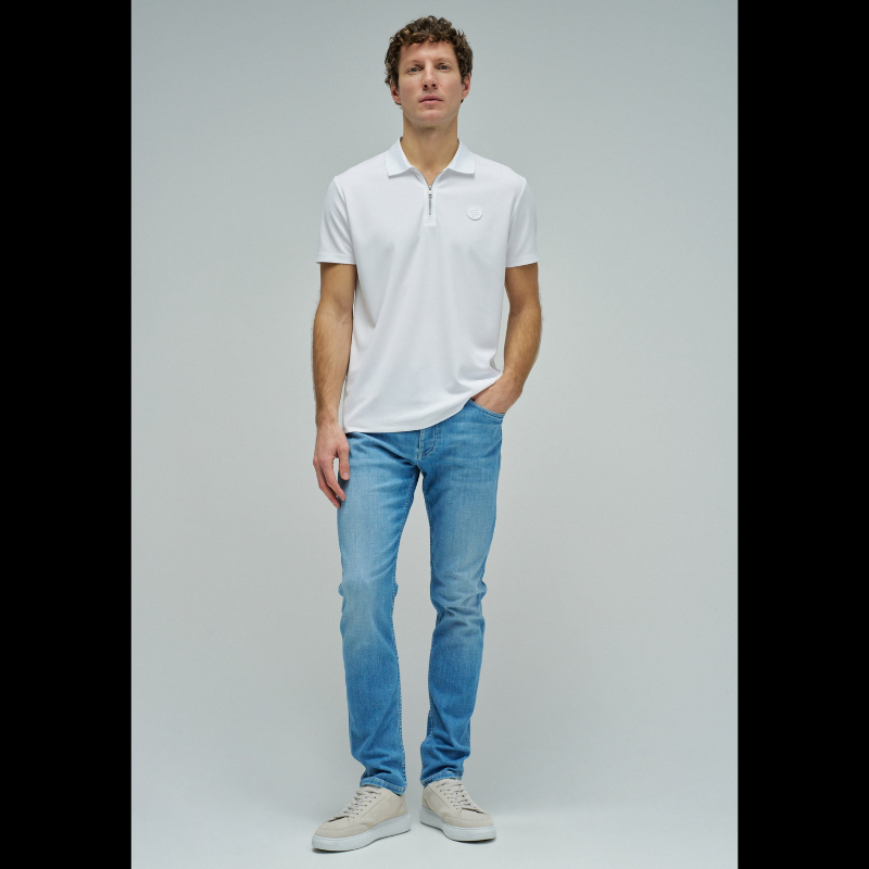 Calças jeans slim fit em azul claro com cintura média e perna ajustada. Apresenta abertura com botões, cinco bolsos funcionais e presilhas para cinto. Corte moderno que realça a silhueta, ideal para um visual casual e versátil no dia a dia.