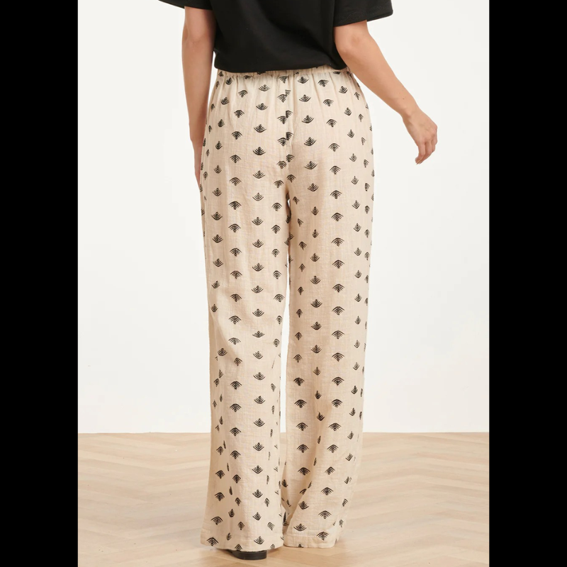 Calças beges Wide Leg com estampado Azteca em preto e castanho. Calças com bolsos nas laterais e cintura com elástico na parte de trás.