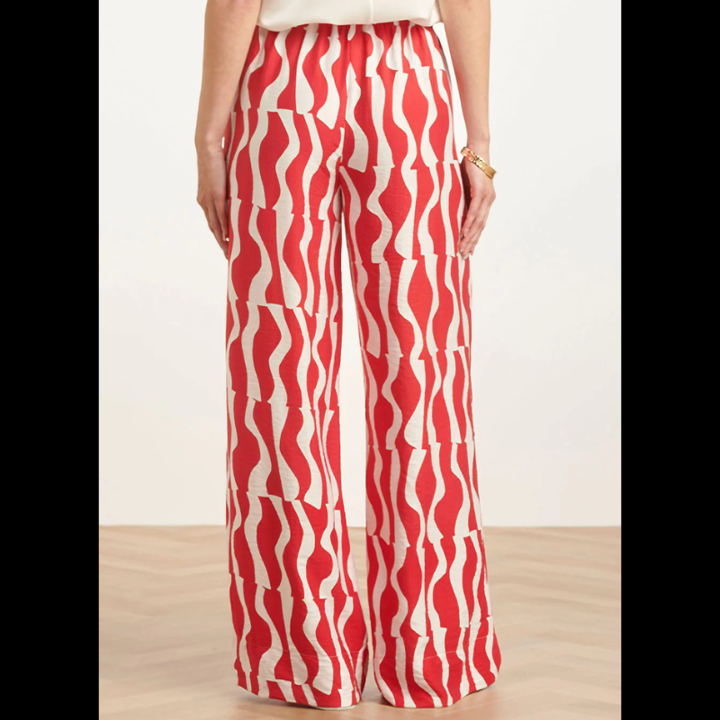 Calças largas com estampa ondulada em vermelho e branco que combinam conforto e estilo. Cintura elástica com atilho ajustável para um encaixe perfeito. Bolsos funcionais para praticidade do dia a dia. Peça versátil que funciona tanto em looks casuais como em composições mais descontraídas.