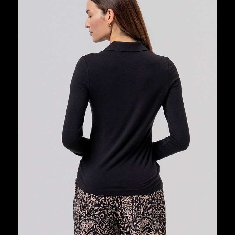 Camisa preta justa em fina viscose de bambu, macia e leve. Gola clássica, fechamento de botão à mesma cor e mangas longas, com uma sensação muito confortável de camisa.