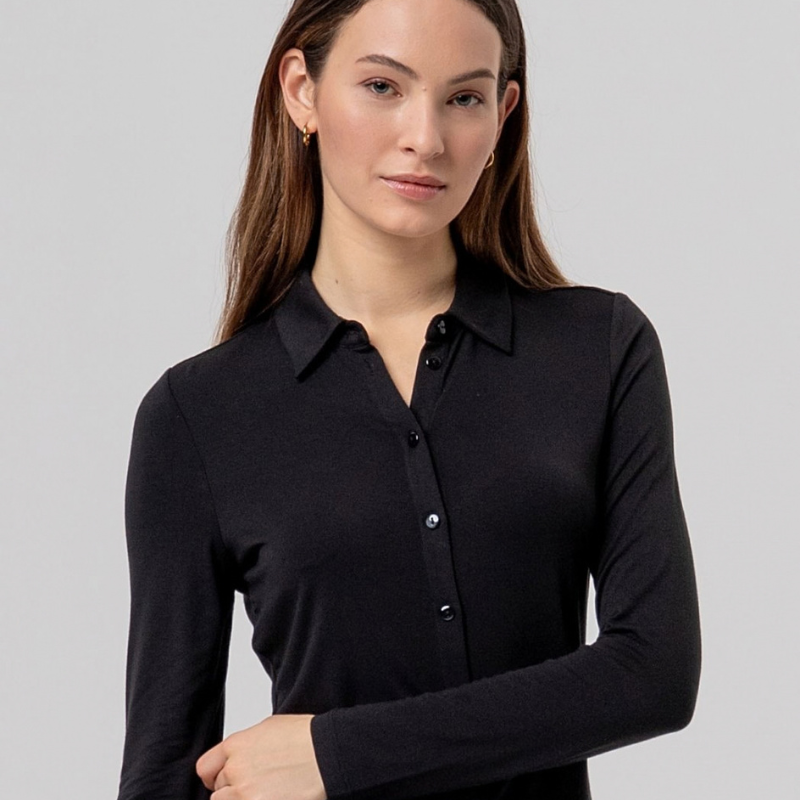 Camisa preta justa em fina viscose de bambu, macia e leve. Gola clássica, fechamento de botão à mesma cor e mangas longas, com uma sensação muito confortável de camisa.