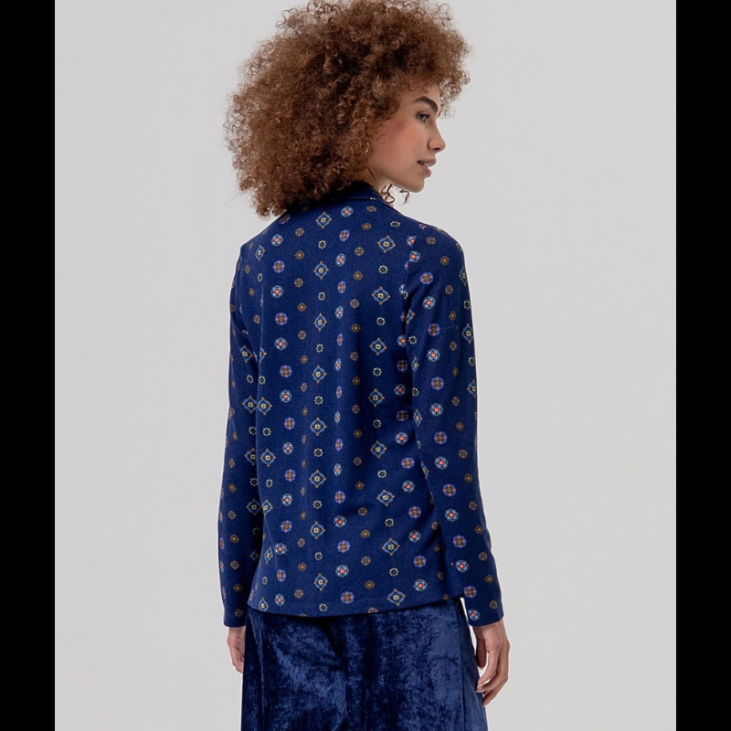 Camisa clássica em azul-marinho com gola e mangas longas, botões azuis e tecido fluido de queda suave. Estampa foulard com medalhões geométricos pequenos que transmitem elegância e sofisticação cosmopolita.