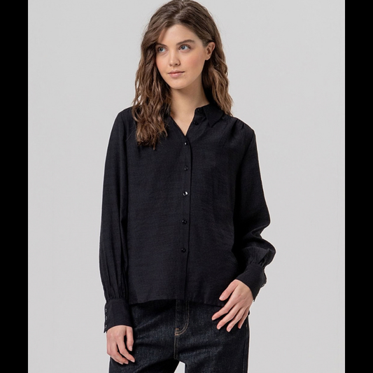 Camisa de manga comprida em preto fluida com gola e botões na frente. Ombros com franzidos que dão volume e punhos bufantes. Tecido leve com toque suave e queda limpa.