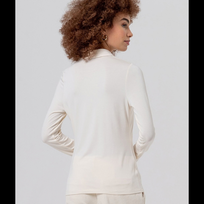 Camisa justa, em crú, em fina viscose de bambu, macia e leve. Gola clássica, fechamento de botão à mesma cor e mangas longas, com uma sensação muito confortável de camisa.
