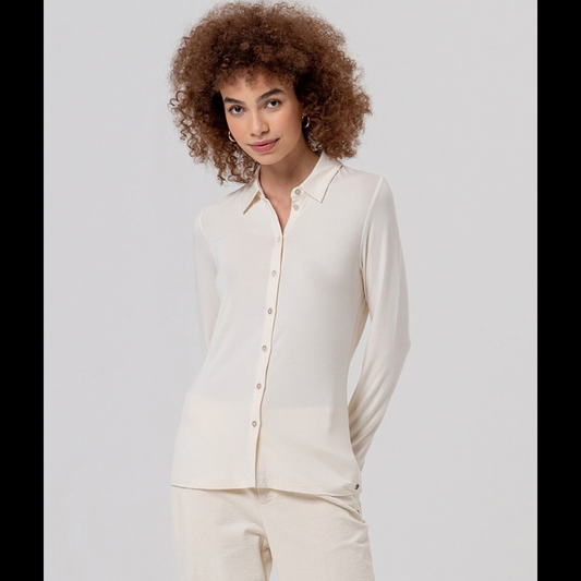 Camisa justa, em crú, em fina viscose de bambu, macia e leve. Gola clássica, fechamento de botão à mesma cor e mangas longas, com uma sensação muito confortável de camisa.