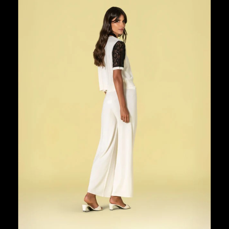 Peça versátil em tom natural, esta Camisola e Pólo combina conforto e sofisticação através do contraste entre a malha lisa e as mangas em renda preta com um acabamento delicado em crú. O decote apresenta detalhes refinados com acabamento em preto e uma delicada risca em caramelo, criando um visual elegante e contemporâneo. Ideal para quem procura uma peça que transita facilmente entre o casual e o mais elaborado.