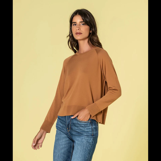 Camisola confecionada em malha fina de qualidade superior, esta camisola combina conforto e refinamento. O decote redondo discreto e o corte solto criam uma silhueta equilibrada e favorecedora. Na tonalidade caramelo, oferece uma alternativa sofisticada ao neutro clássico, mantendo a versatilidade necessária para múltiplas combinações. Uma investimento inteligente para um guarda-roupa atemporal e funcional.