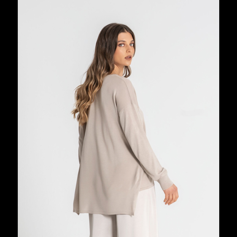 Camisola de malha fina, em bege, com manga comprida e decote redondo. O design oversize oferece um caimento solto e confortável, com comprimento mais alongado na parte traseira para um visual moderno e descontraído.