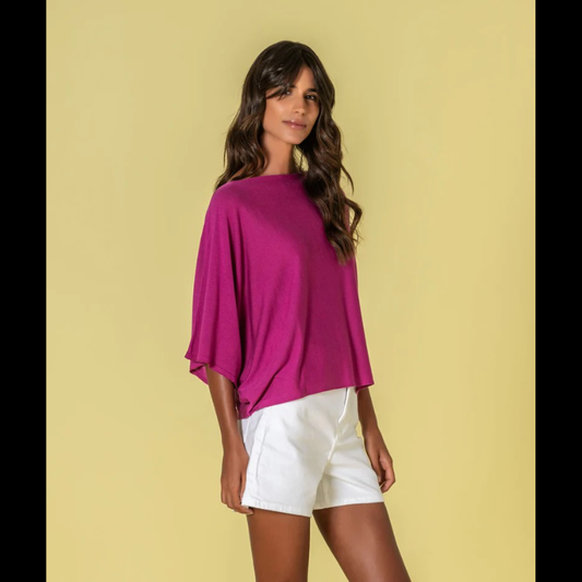 Camisola de corte amplo com decote redondo em fúcsia, peça versátil que combina conforto e estilo contemporâneo. O tom vibrante destaca-se como elemento central do guarda-roupa, enquanto o ajuste generoso permite múltiplas formas de styling, desde looks casual até propostas mais elaboradas.