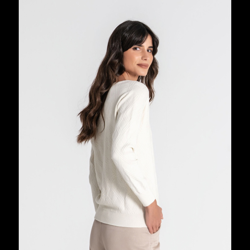 Camisola de malha fofinha com manga comprida e decote em V. Apresenta uma textura em relevo de losangos que confere profundidade e elegância ao design. A marca é destacada pela aplicação da chapa R em dourado no peito, um toque sofisticado que valoriza qualquer look. 