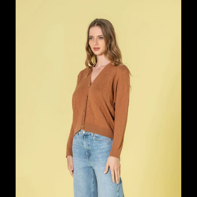 Casaco em tom caramelo com relevo animal print que traz profundidade e dinamismo ao seu estilo. O decote V proporciona uma linha elegante e alongadora, complementado por botões dourados com assinatura de marca que elevam o design. Peça de grande versatilidade, perfeita para composições sofisticadas tanto em contextos casuais como em momentos que exigem maior formalidade.