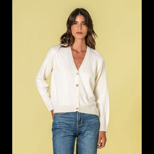 Casaco em tom crú com relevo animal print que traz profundidade e dinamismo ao seu estilo. O decote V proporciona uma linha elegante e alongadora, complementado por botões dourados com assinatura de marca que elevam o design. Peça de grande versatilidade, perfeita para composições sofisticadas tanto em contextos casuais como em momentos que exigem maior formalidade.