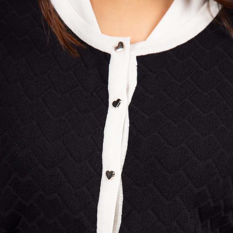 Casaco de malha jacquard, da linha Infinito, com decote redondo e mangas compridas que garantem intemporalidade, enquanto o padrão jacquard adiciona textura e profundidade onde conforto e elegância se encontram. Confecionado em malha suave e elástica, oferece um vestir estruturado e confortável para o dia a dia. O destaque especial vai para a fileira de botões em formato de coração, um detalhe feminino que confere personalidade sem excessos.