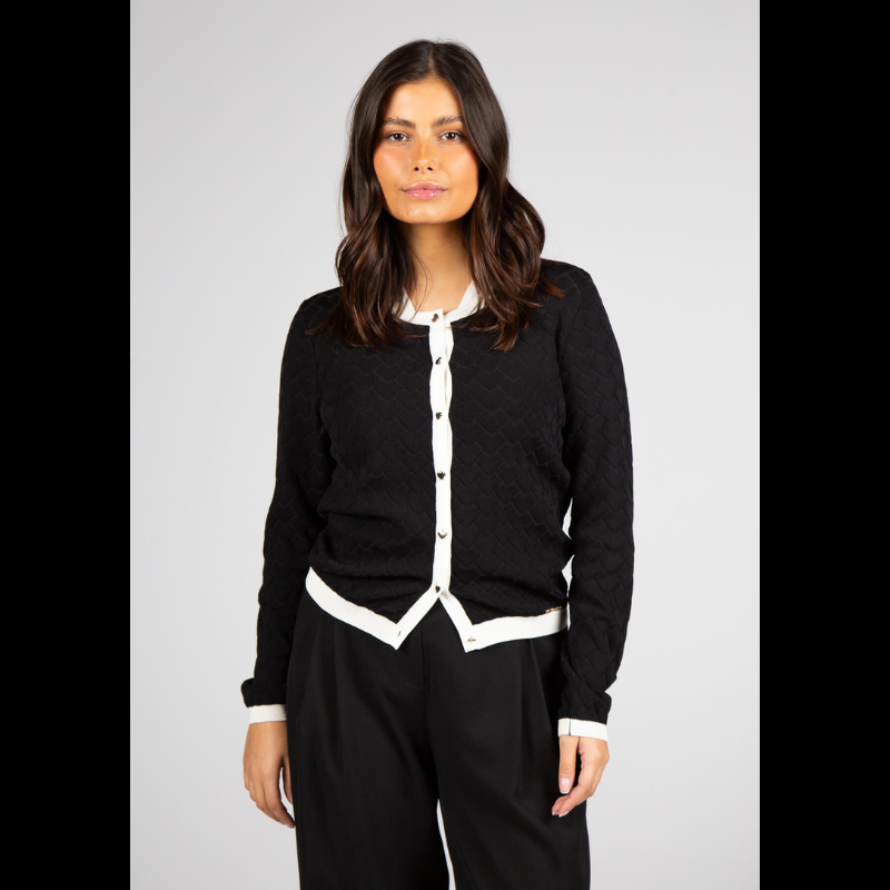 Casaco de malha jacquard, da linha Infinito, com decote redondo e mangas compridas que garantem intemporalidade, enquanto o padrão jacquard adiciona textura e profundidade onde conforto e elegância se encontram. Confecionado em malha suave e elástica, oferece um vestir estruturado e confortável para o dia a dia. O destaque especial vai para a fileira de botões em formato de coração, um detalhe feminino que confere personalidade sem excessos.