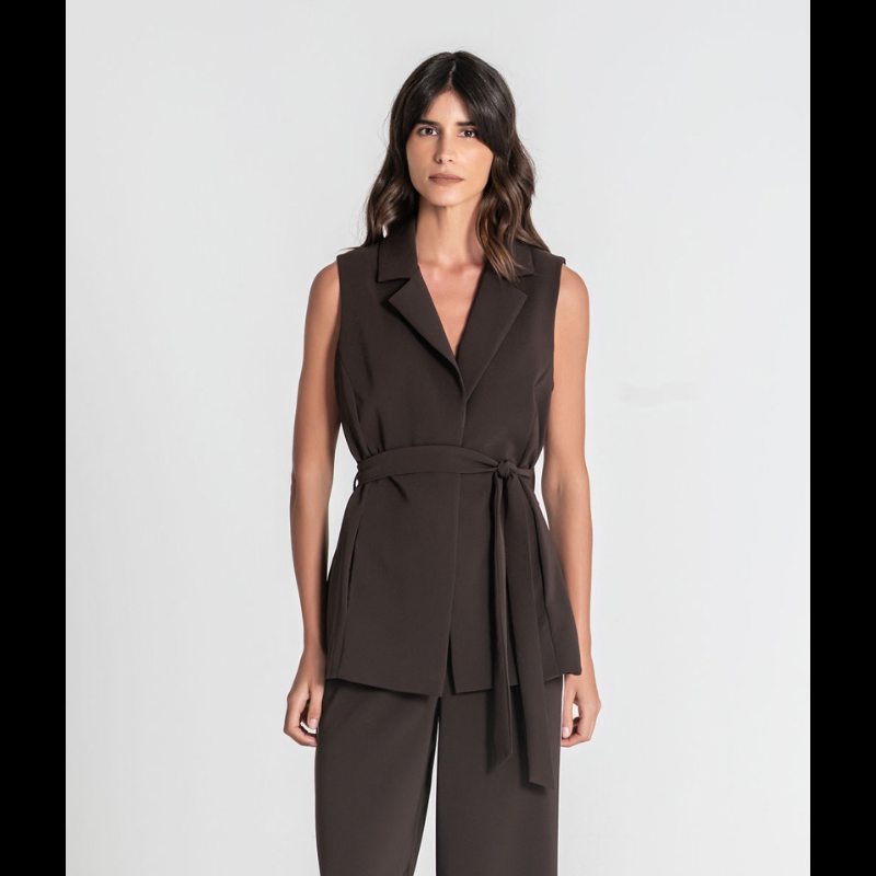 Colete elegante em castanho moka, ideal para criar looks sofisticados e versáteis. O cinto incorporado e a risca branca na lateral conferem um acabamento refinado e moderno. Fechadura frontal com botão forrado no mesmo tecido garante um visual coeso. Os bolsos invisíveis oferecem funcionalidade discreta sem comprometer o design limpo. 
