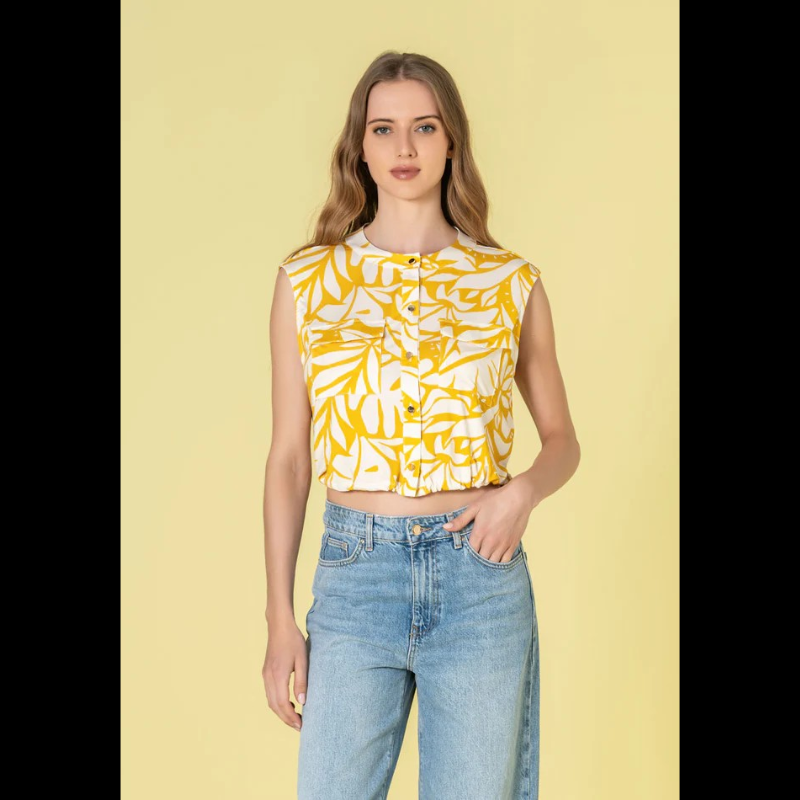 Colete versátil em tons quentes de bege e amarelo, com um padrão floral delicado que traz movimento e personalidade a qualquer look. O decote com gola a padre confere sofisticação, enquanto os botões dourados adicionam um toque de luxo. A cintura ajustável com elástico permite um ajuste personalizado para máximo conforto. Os bolsos funcionais de chapa com pala no peito combinam praticidade com estilo, tornando este colete tanto elegante quanto versátil para o dia a dia.