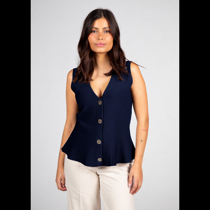 Colete da linha Infinito, muito elegante e versátil que apresenta um corte sofisticado com decote em V e efeito peplum que valoriza a silhueta. O azul marinho transmite confiança e intemporalidade, enquanto os botões dourados adicionam um detalhe refinado e distinto. Combina perfeitamente com branco, pérola, bege, ganga ou cores mais intensas para looks contemporâneos. Ideal tanto para ambientes profissionais como para coordenados descontraídos, mantendo sempre a elegância.