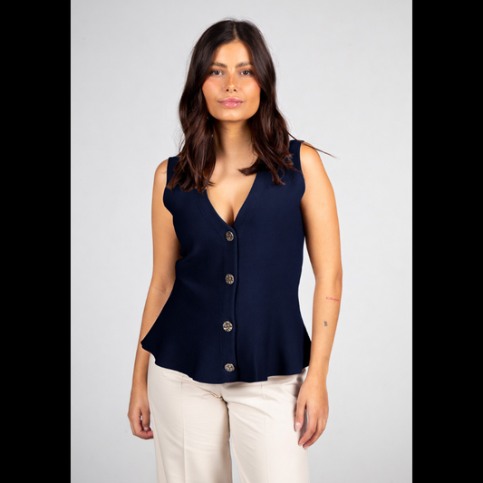 Colete da linha Infinito, muito elegante e versátil que apresenta um corte sofisticado com decote em V e efeito peplum que valoriza a silhueta. O azul marinho transmite confiança e intemporalidade, enquanto os botões dourados adicionam um detalhe refinado e distinto. Combina perfeitamente com branco, pérola, bege, ganga ou cores mais intensas para looks contemporâneos. Ideal tanto para ambientes profissionais como para coordenados descontraídos, mantendo sempre a elegância.