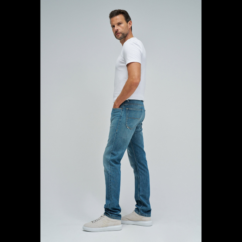 Calças jeans clássicas com corte regular fit que combina conforto e estilo. Apresenta uma tonalidade azul esverdeada sofisticada e cintura média para um ajuste equilibrado. O novo Air Blend Denim nasce para os dias mais quentes, sem comprometer aquilo que realmente importa: ajuste preciso, presença e durabilidade. Fechamento com botões na frente e perna regular que segue a silhueta natural. Equipadas com cinco bolsos funcionais. Ideal para o dia a dia, estas calças oferecem versatilidade para criar looks ca