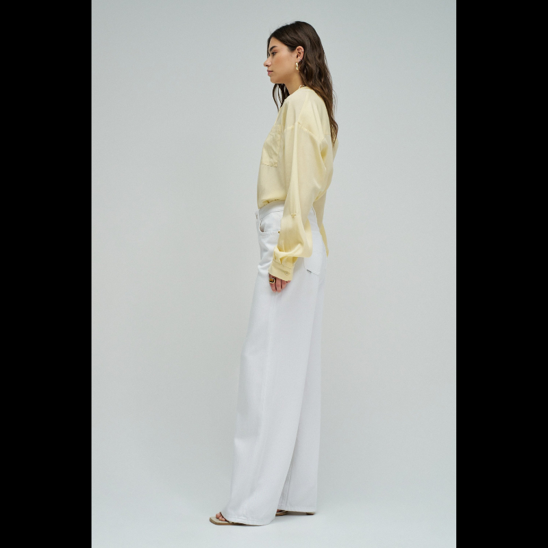 Calças jeans wide leg em branco puro que combinam estilo e conforto. O corte amplo na perna oferece liberdade de movimento e um visual moderno e descontraído. Equipadas com cinco bolsos funcionais, fecho de correr e botão na cintura para um ajuste seguro, além de presilhas para cinto. Peça versátil que funciona tanto em looks casuais como em composições mais sofisticadas.